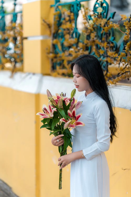 Woman in Traditional Clothing Standing with Flowers