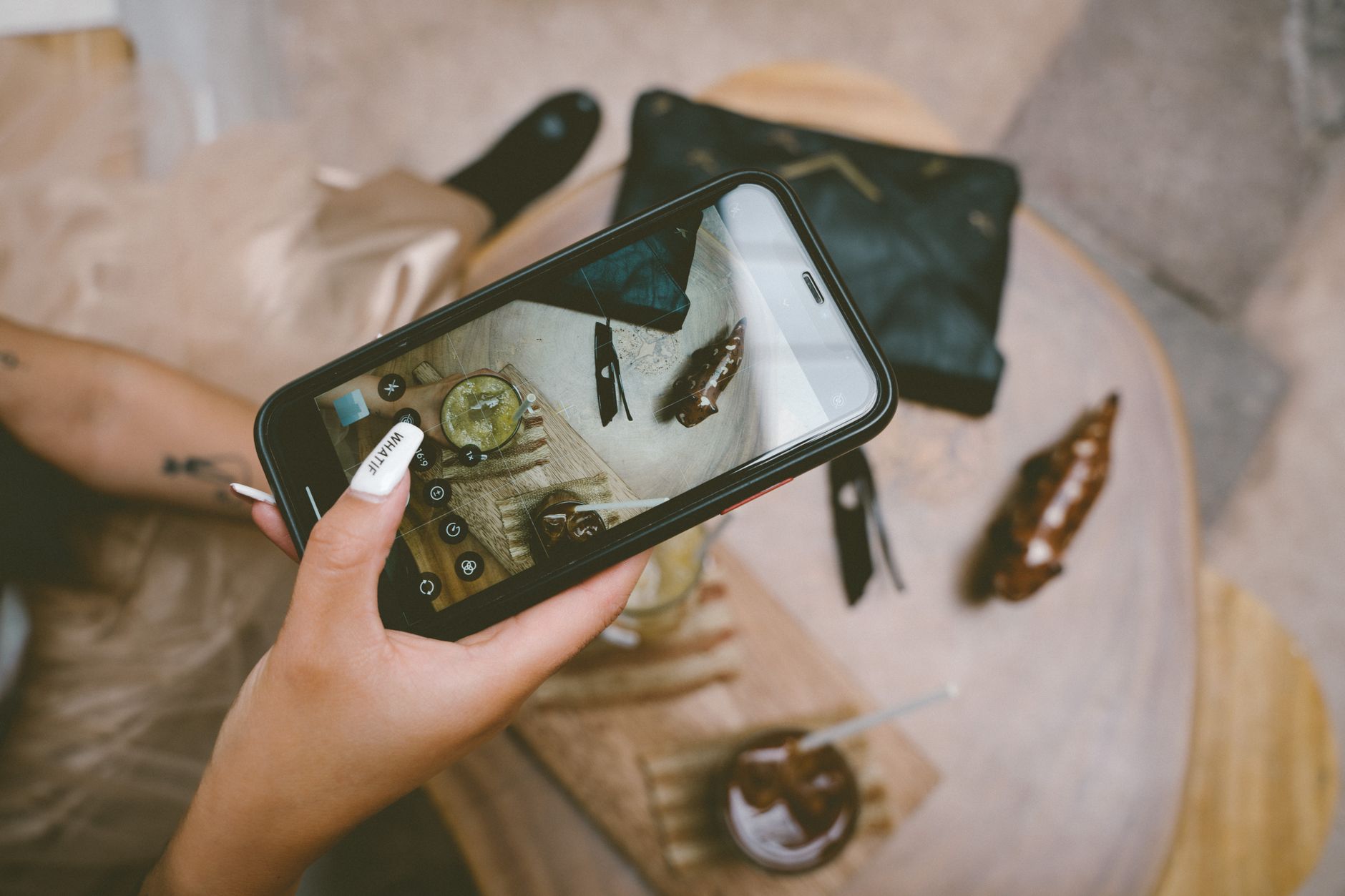 Woman taking a photo of a stylish table setting with a smartphone in Cusco, Peru.