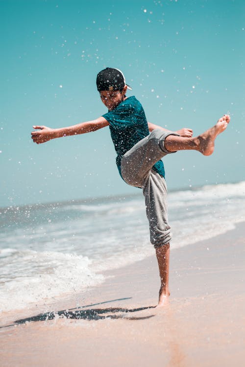 Boy Kicking Sand On Shore