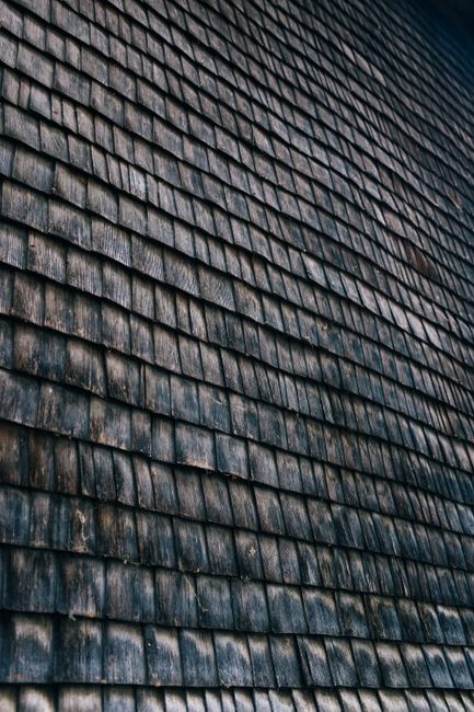 Close-up of an old wooden rooftop with textured, weathered shingles forming a unique pattern.