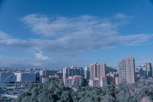 Panoramic view of an urban skyline with residential buildings under a clear blue sky.