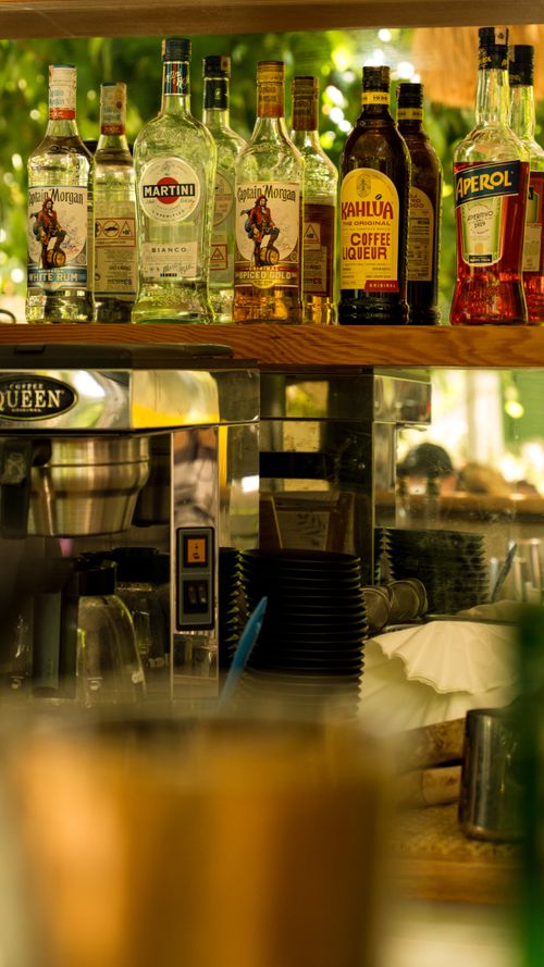 Free A selection of liquor bottles displayed on a bar shelf in a cozy setting. Stock Photo