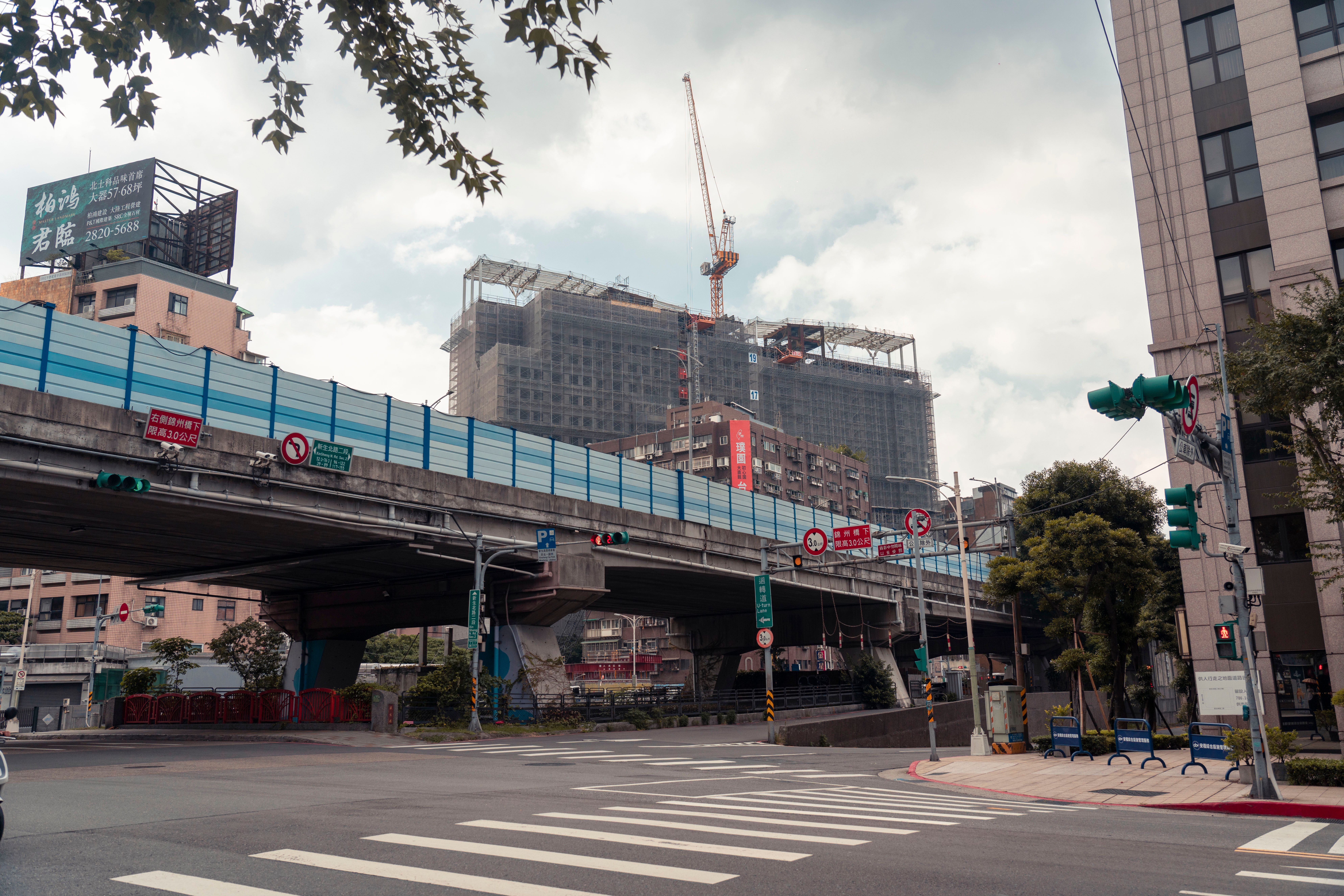 View of urban cityscape showing an overpass and construction site with a crane.