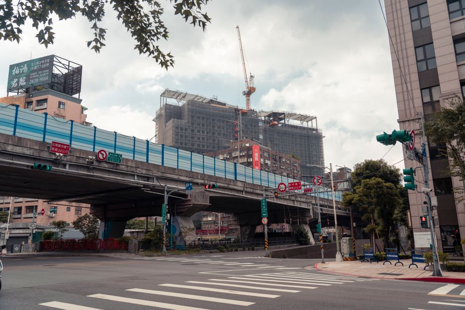 View of urban cityscape showing an overpass and construction site with a crane.