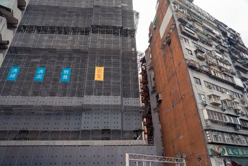 Free Urban construction site with scaffolding and high-rise buildings in an Asian city street. Stock Photo