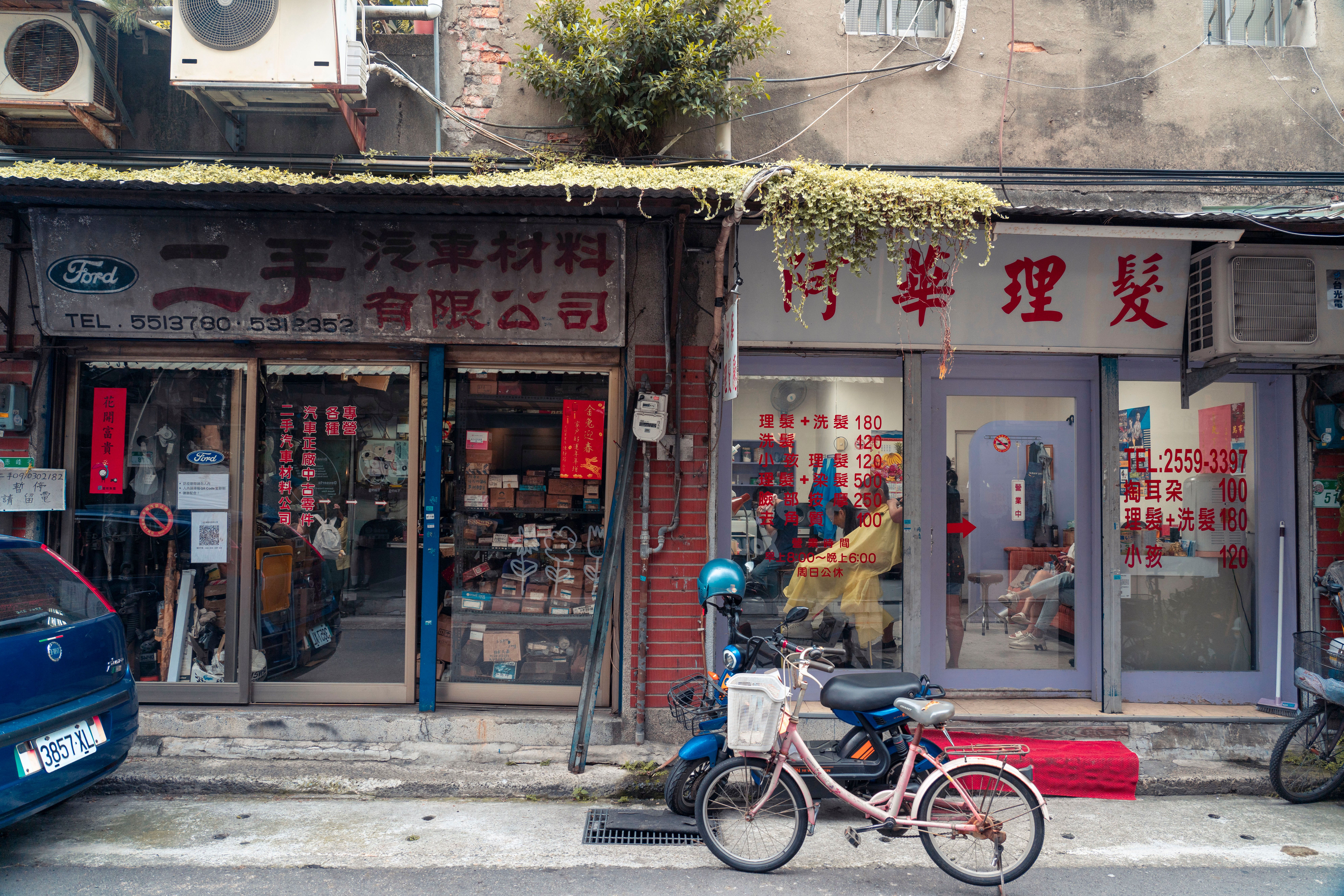A charming street in Taipei showcasing vintage shops and a bicycle, depicting local urban life.