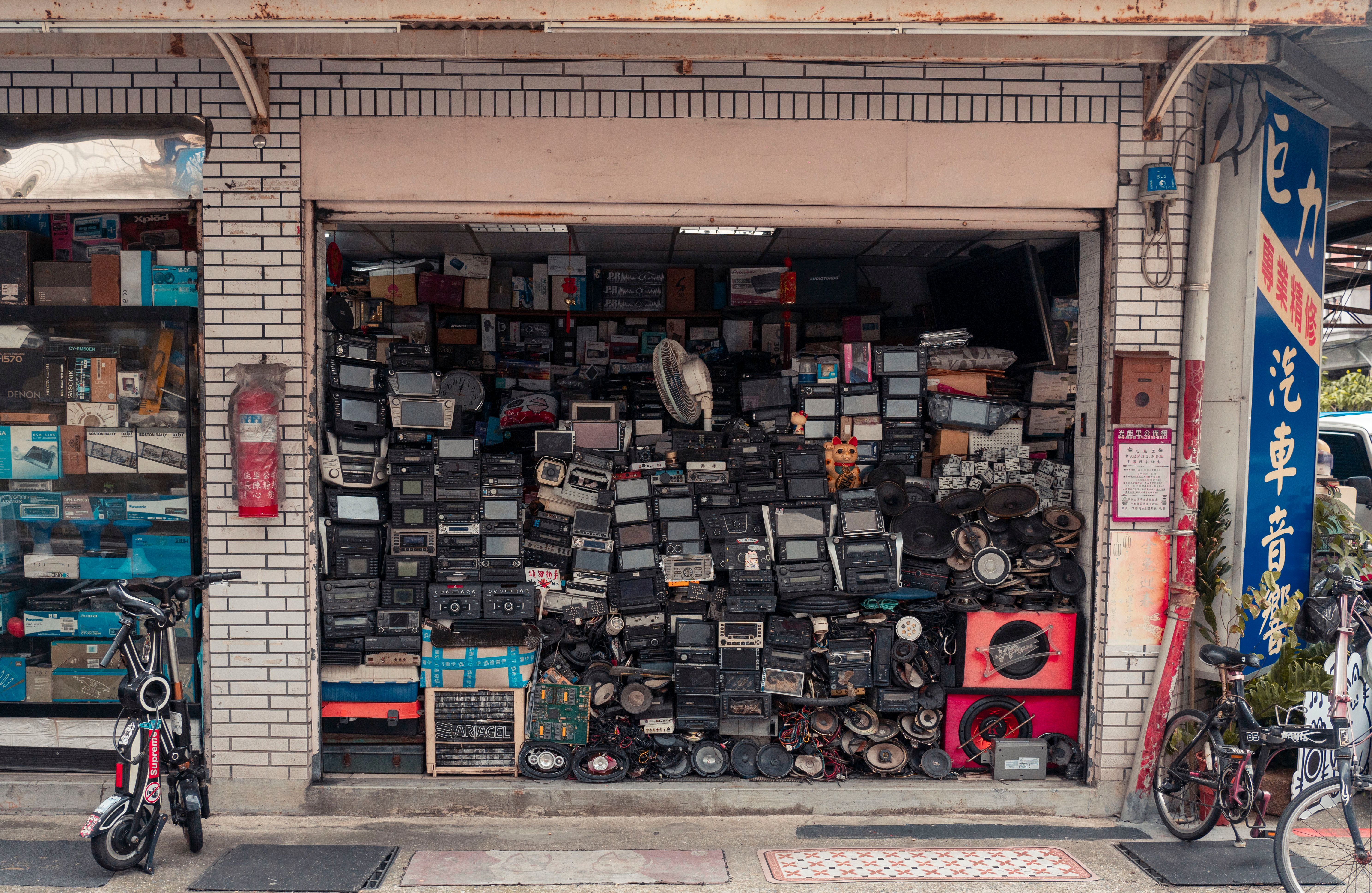 A cluttered street shop displaying vintage radios and electronics, creating a nostalgic urban scene.