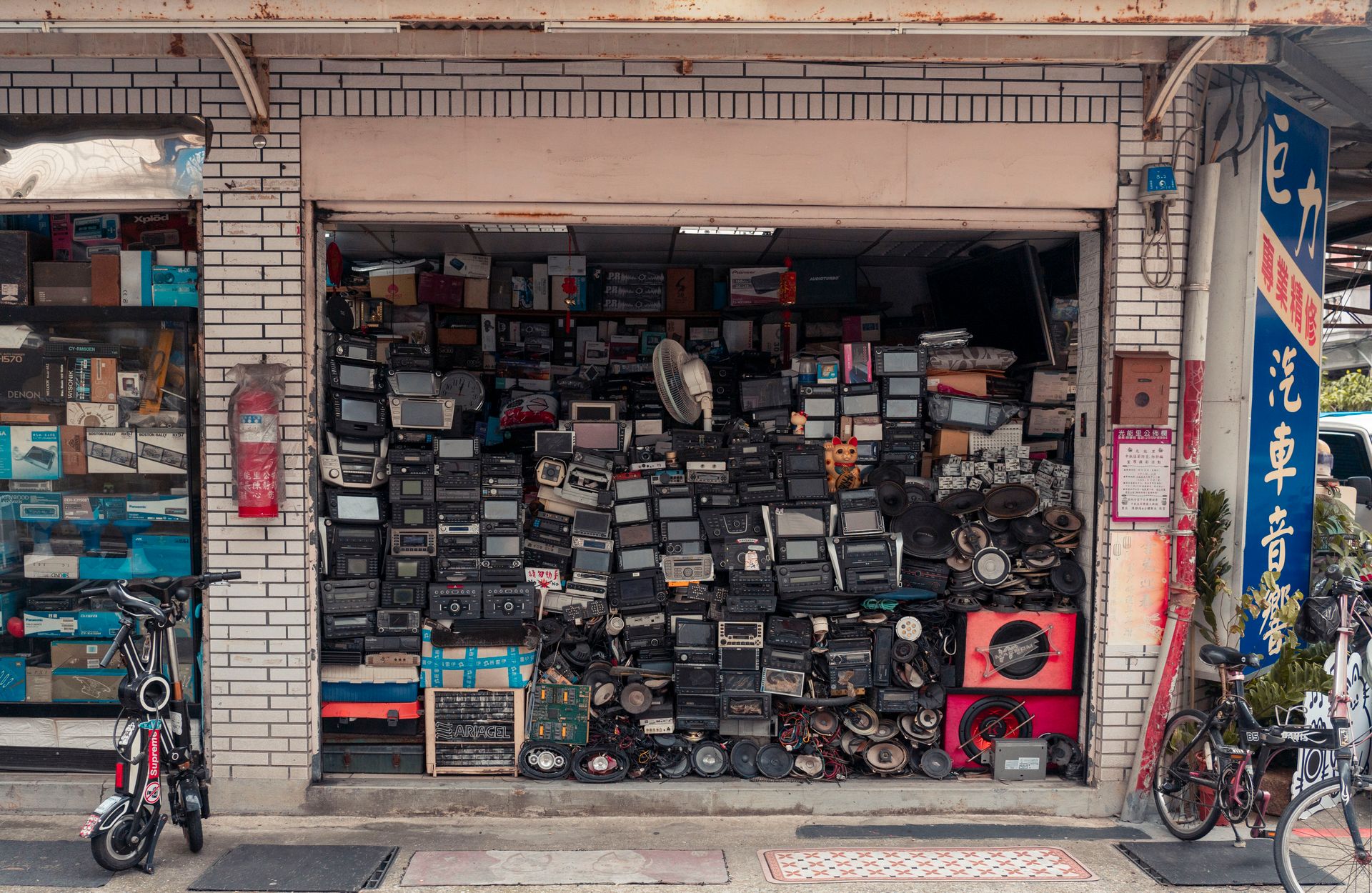 A cluttered street shop displaying vintage radios and electronics, creating a nostalgic urban scene.