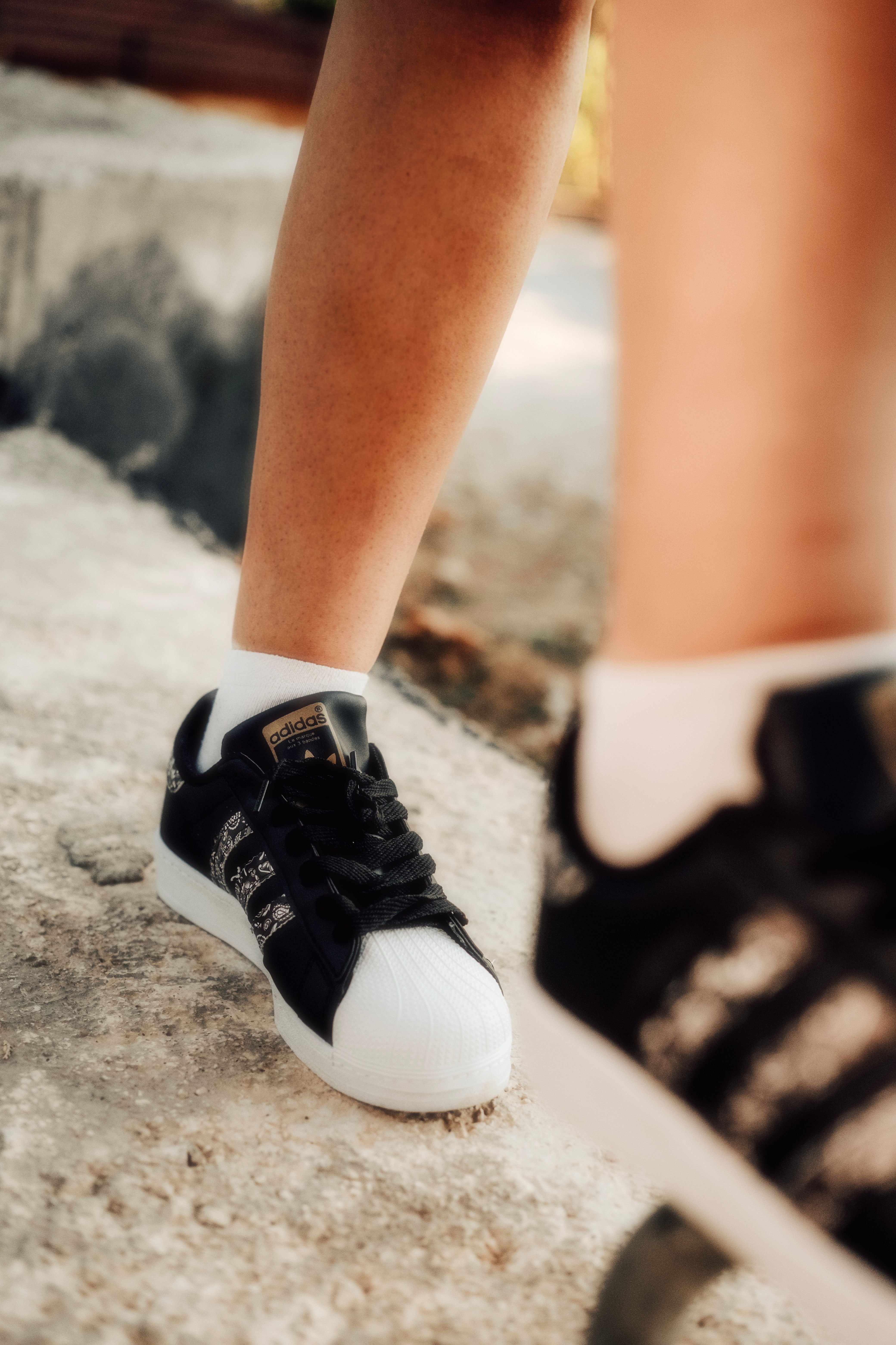 A Person Wearing Adidas Superstar Sneakers  Free Stock Photo