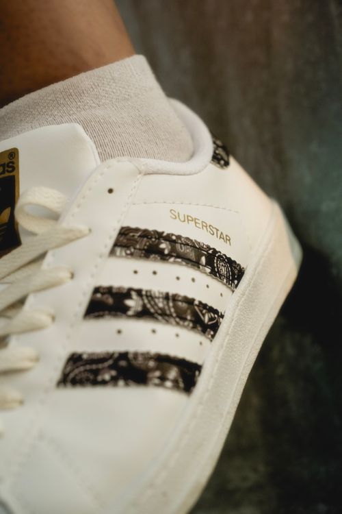 Free Detailed view of white sneakers featuring unique patterned stripes and branding. Stock Photo