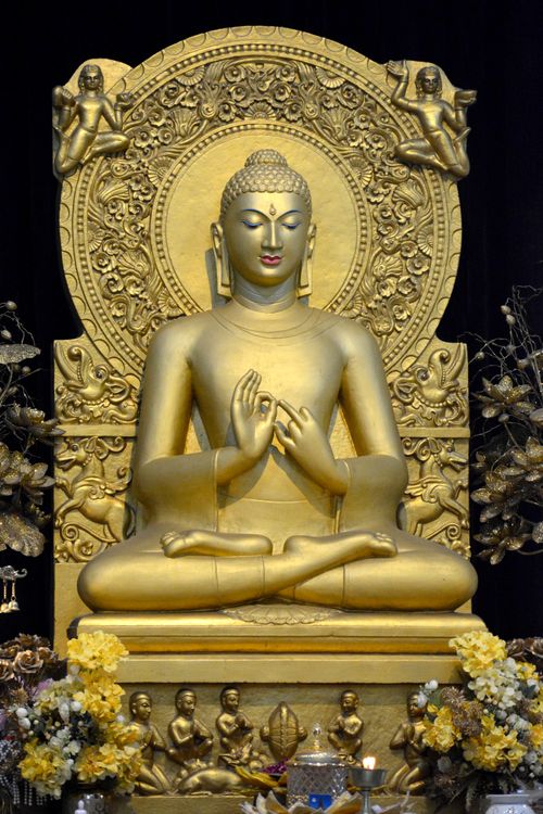 Free Ornate golden Buddha statue in meditation pose at a temple in Varanasi, India. Stock Photo