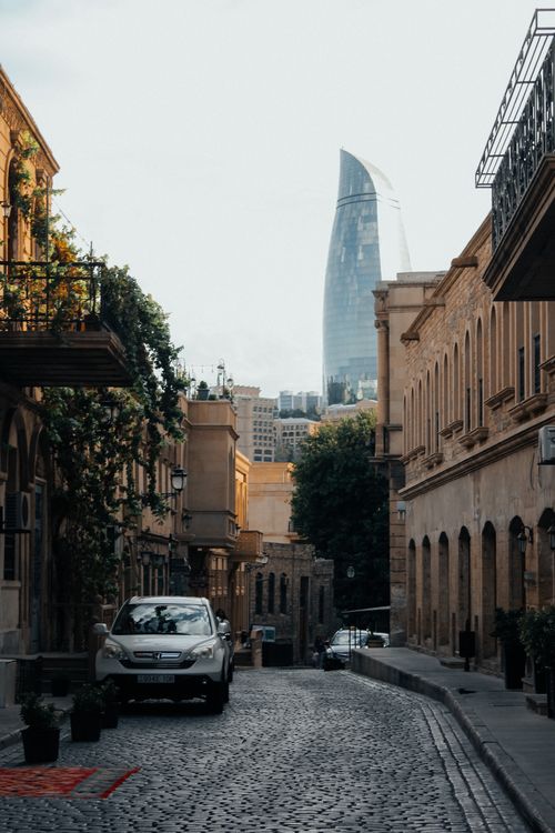 Free Scenic cobblestone street in Baku's Old Town with Flame Towers in view. Stock Photo