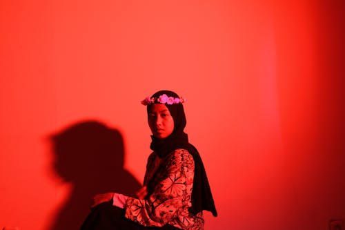 Woman Sitting in Hijab and Flowers Wreath