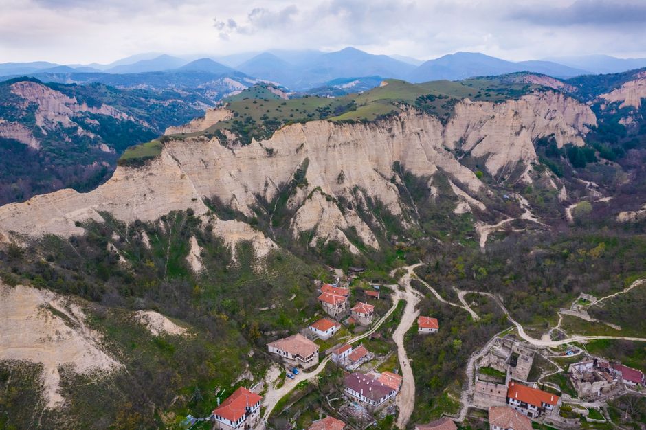 A picturesque vineyard in the Melnik wine region of Bulgaria, with a wine tasting setup, highlighting the local Shiroka Melnishka Loza grape.