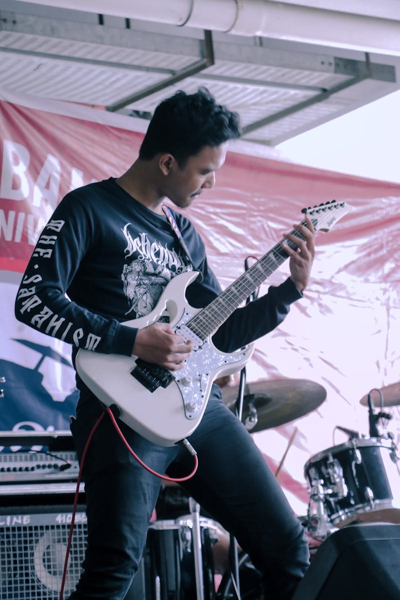 Musician playing electric guitar with energy during a live performance