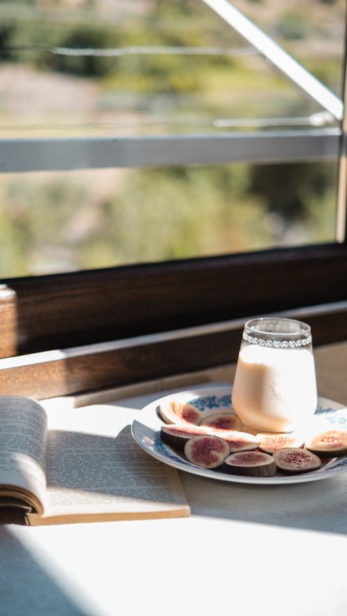 Free Plate of figs and a glass of milk by sunlight, perfect for a cozy morning. Stock Photo