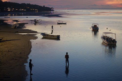 Boats and People on a Beach at Dusk