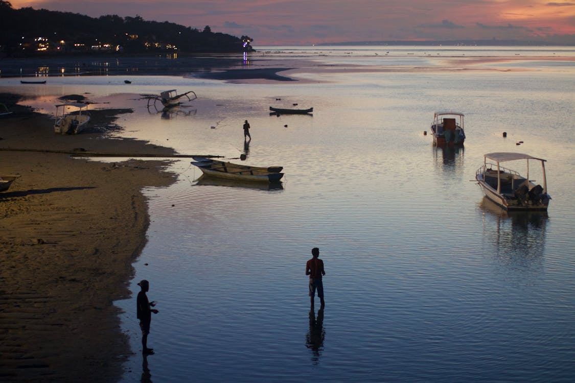 Boats and People on a Beach at Dusk