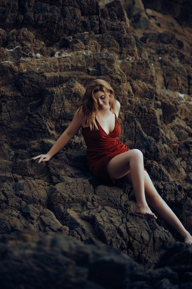 Woman In Red Dress Posing On Rocks