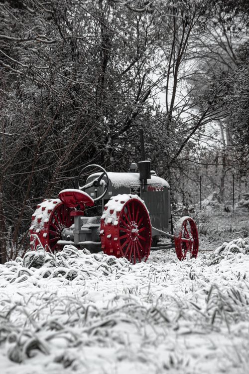 Free Retro tractor with red wheels in a snowy forest landscape. Stock Photo