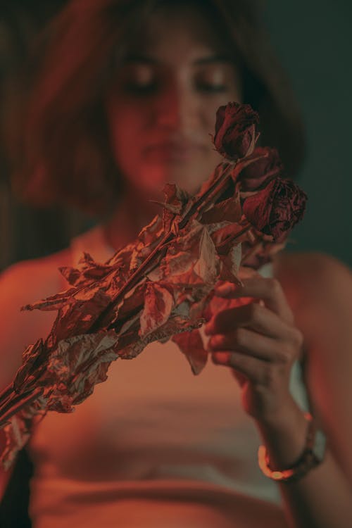 Young Woman Holding a Bunch of Dry Roses