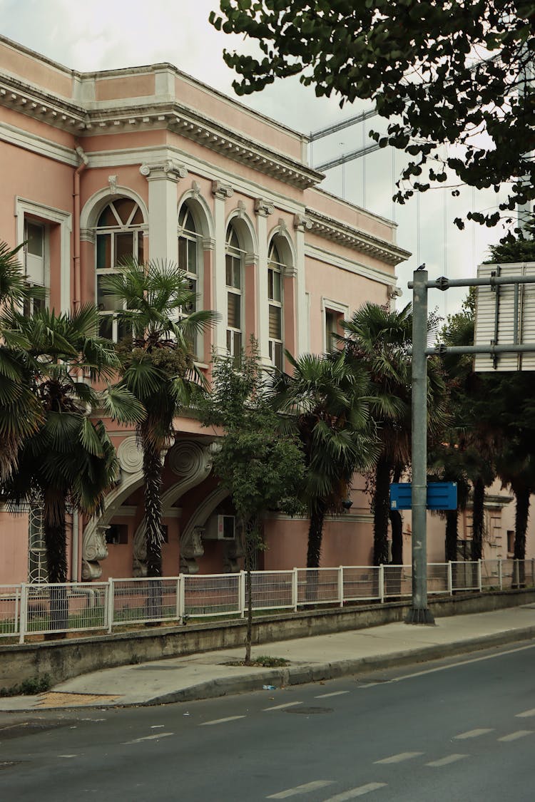 A Street And Facade Of A Building With Palm Trees At The Front In City 