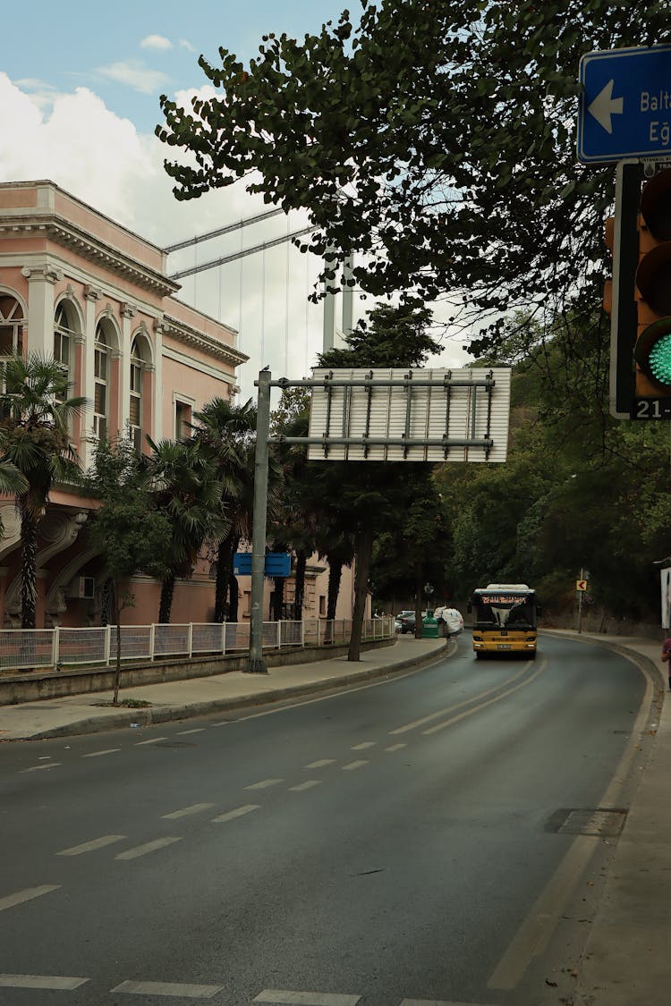 A Street In City With Palm Trees And A Building On The Side