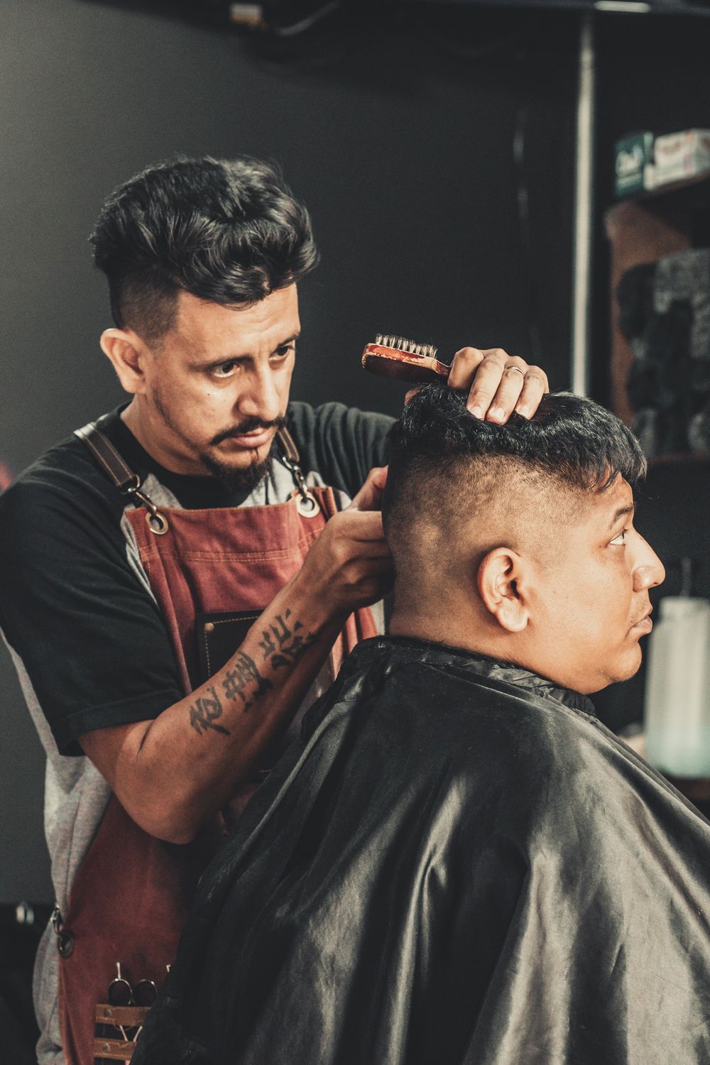 Barbeiro finalizando o corte de um cliente