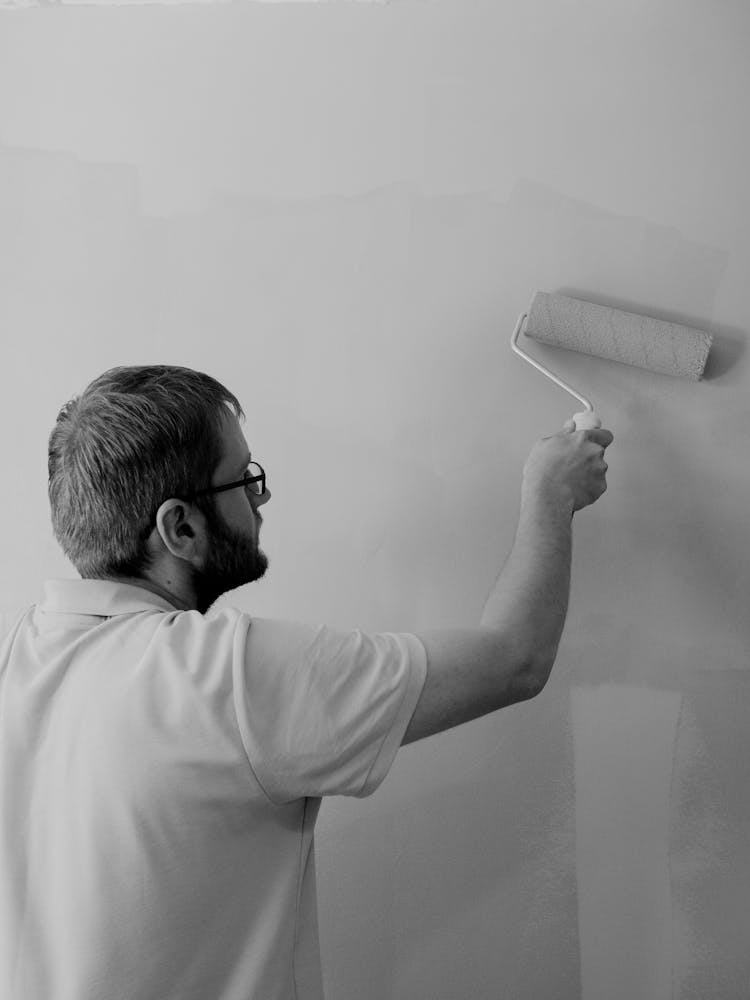 Man Painting Wall With Paint Roller