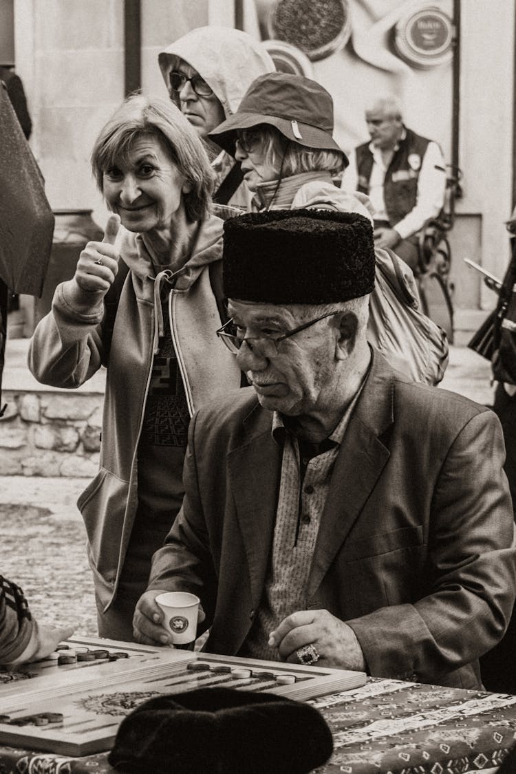 Elderly Man With Hat Playing Board Game On Street