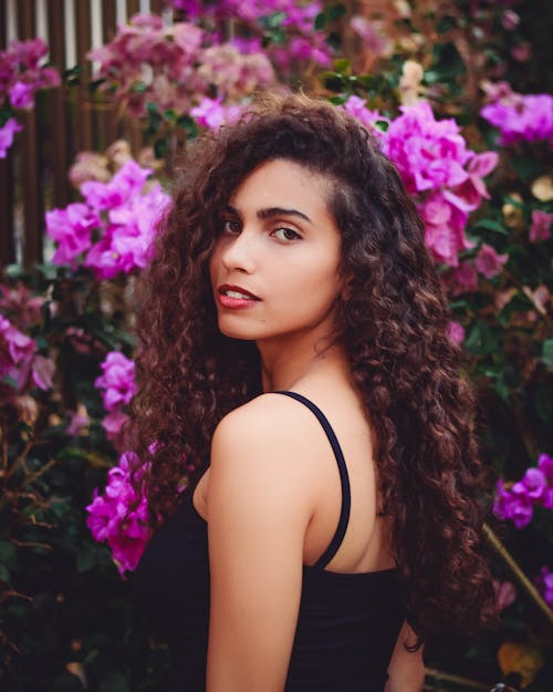 Photographie De Mise Au Point Sélective De Femme à Côté De Fleur Rose