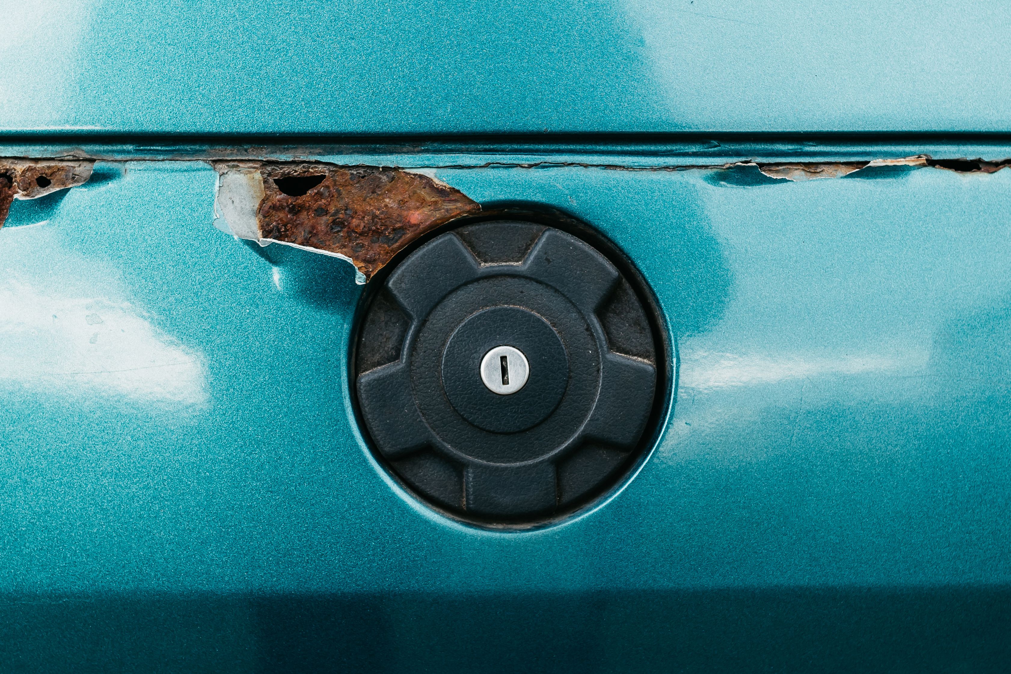 Visible rust corrosion spots on car exterior from winter salt