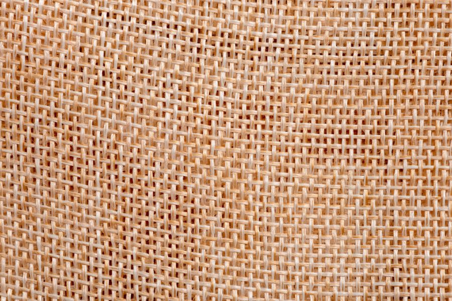 Detailed close-up of natural woven jute fabric pattern, showcasing intricate design.