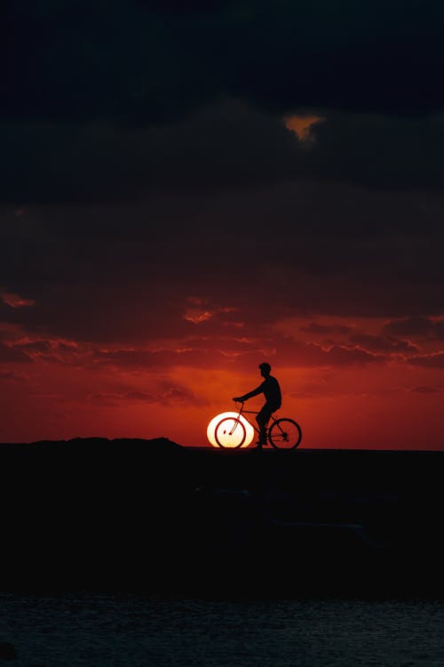 Man Riding a Bike During Sunset