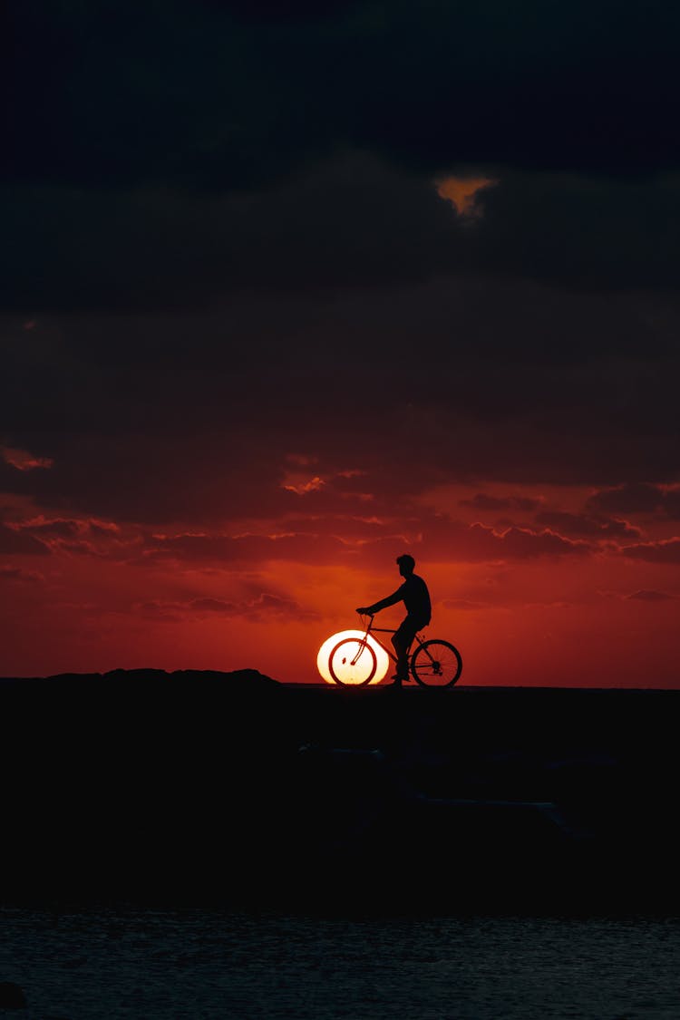 Man Riding A Bike During Sunset