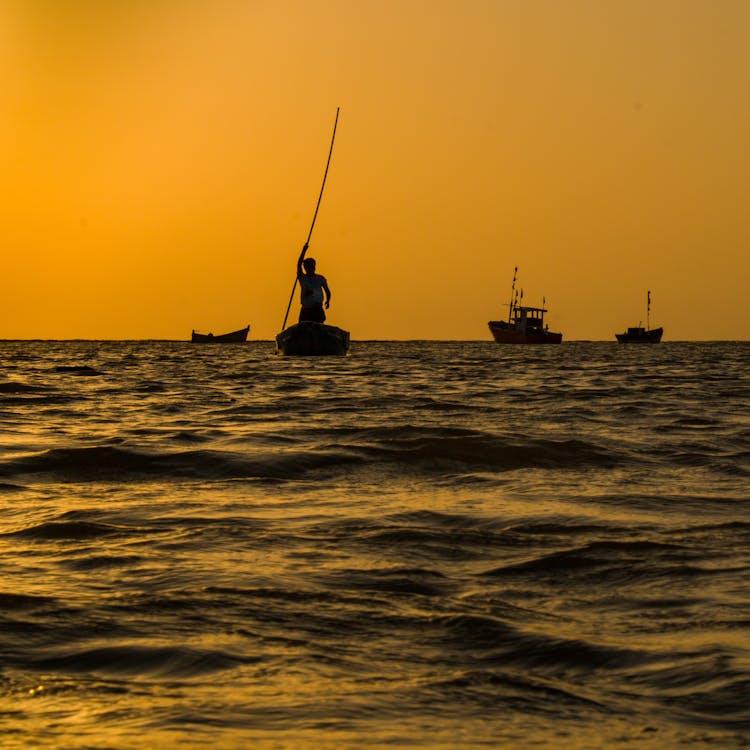 Silhouettes Of Fishing Boats At Sea At Sunrise