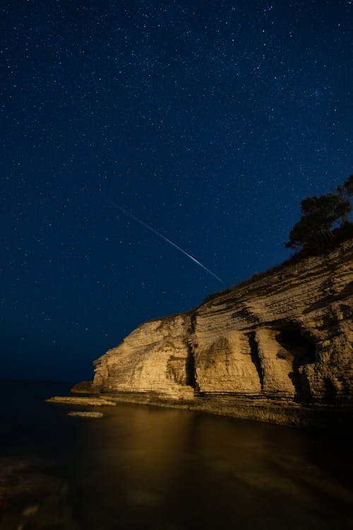 Cliff on the Shore under a Starry Night Sky 