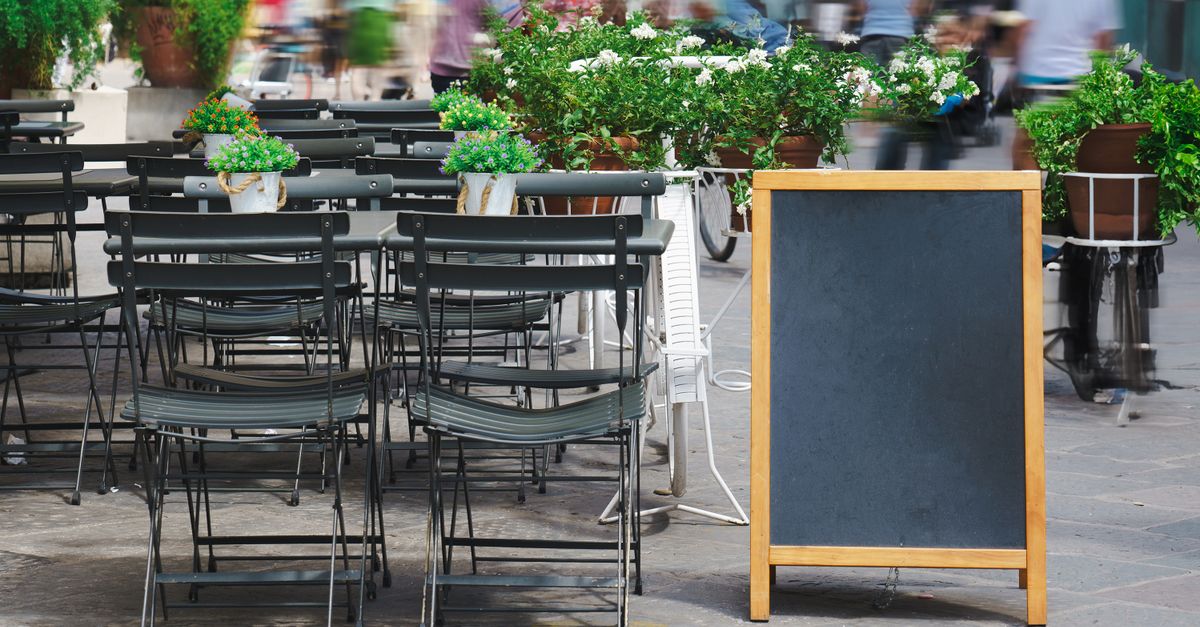 Empty outdoor bistro in Florence, Italy with chairs and plants.