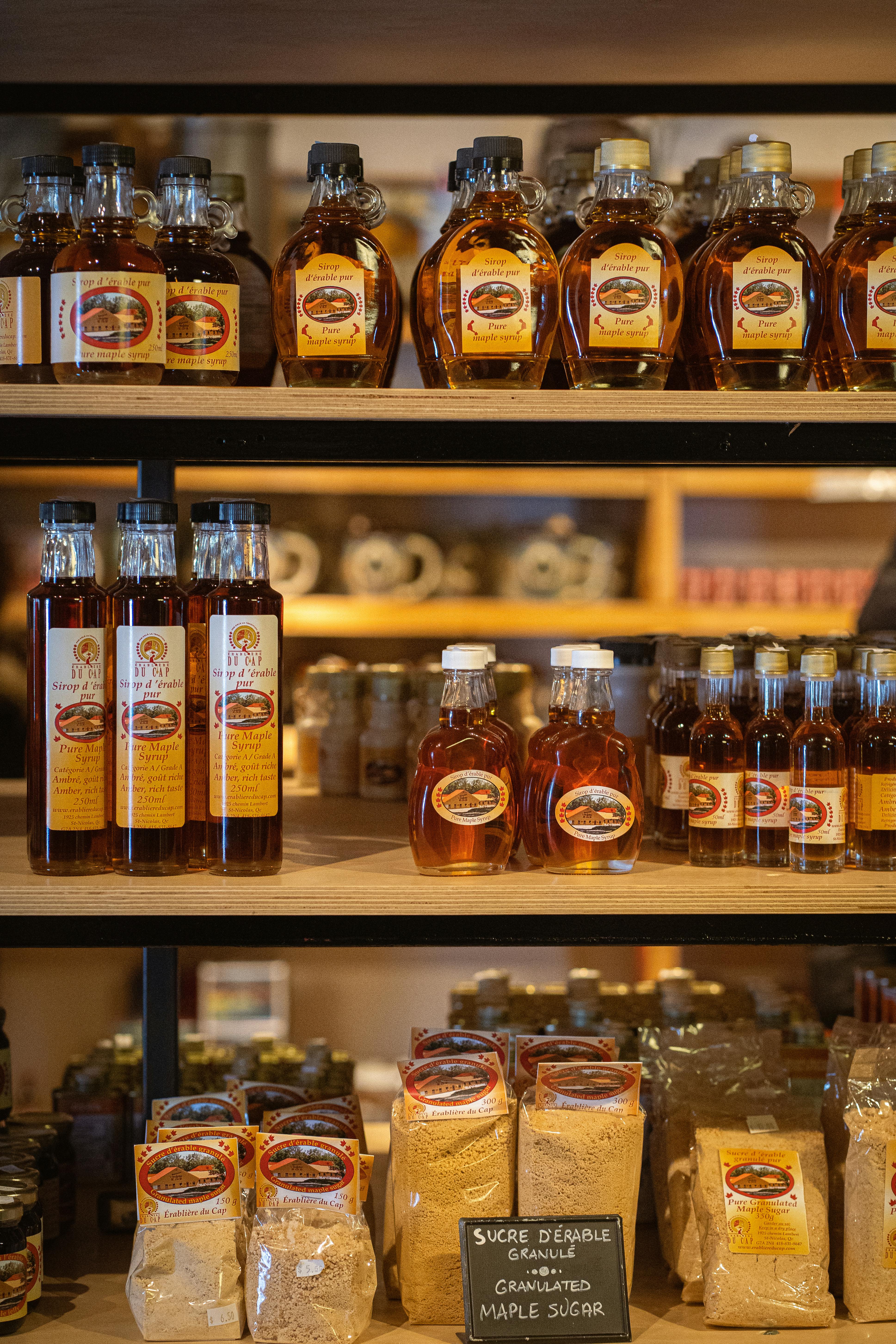 Store Shelves with Bottles of Maple Syrup and Bags of Granulated Maple