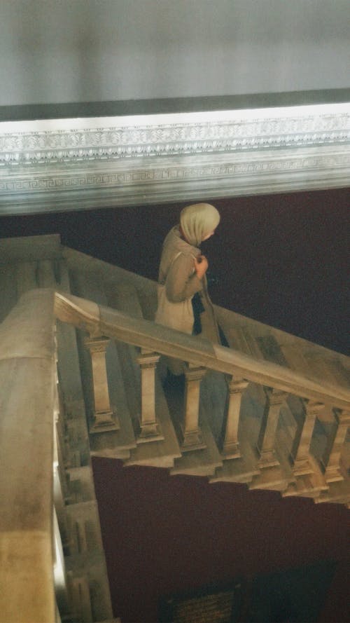 Woman in Hijab Walking Down Stairs