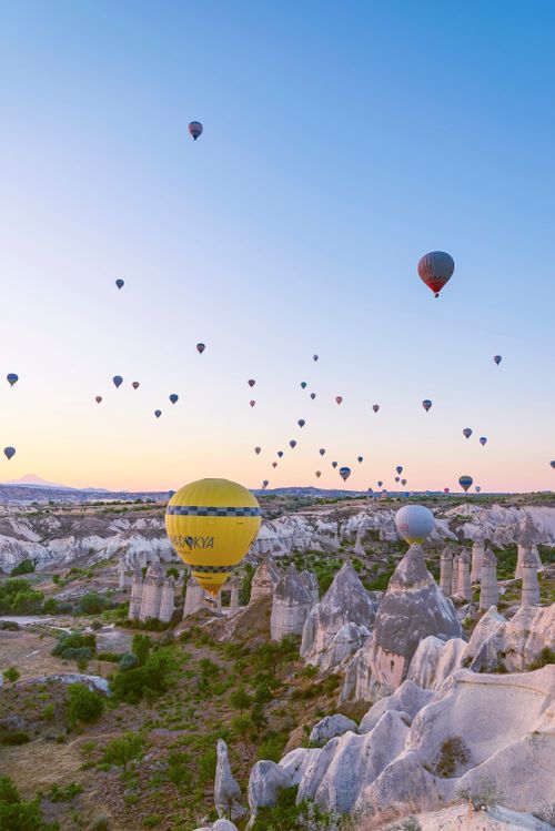 Free Hot air balloons soar above the stunning rock formations of Cappadocia at sunrise. Stock Photo
