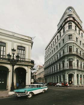 Classic car parked on a street corner in Havana, Cuba, with colonial architecture in the background.