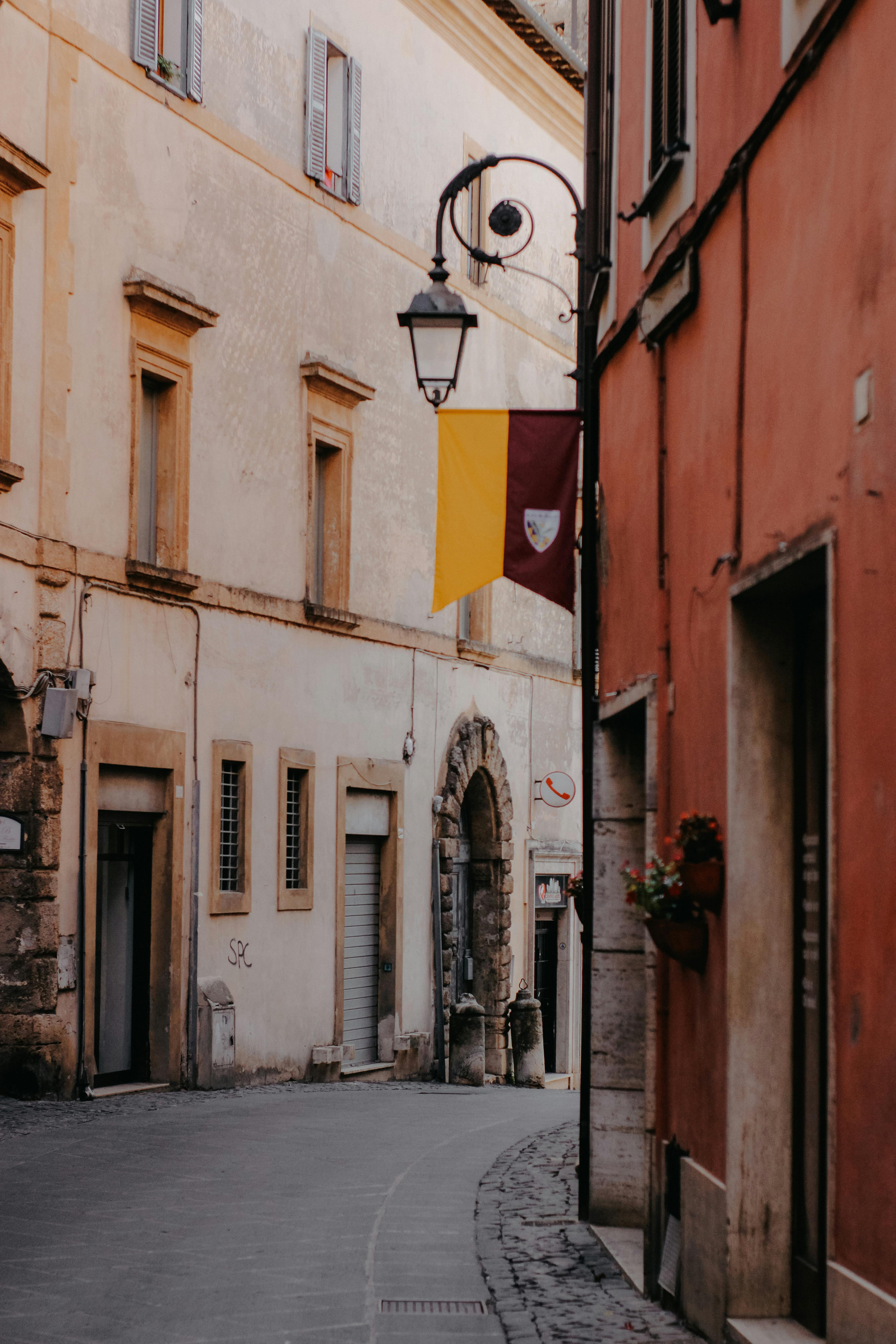 A peaceful narrow street in an old European town with vintage buildings and streetlight.