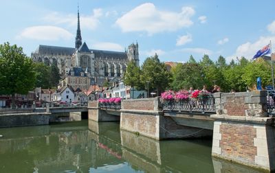 Vue charmante de la cathédrale d'Amiens et du pont avec des reflets d'été et des fleurs.