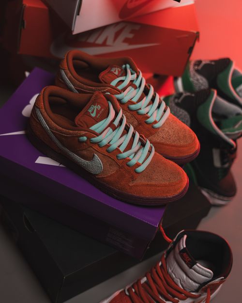 Free Close-up of fashionable sneakers stacked on colorful boxes in a store setting. Stock Photo