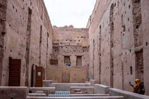 Free Tourists exploring El Badi Palace's historic walls in Marrakesh, Morocco. Stock Photo
