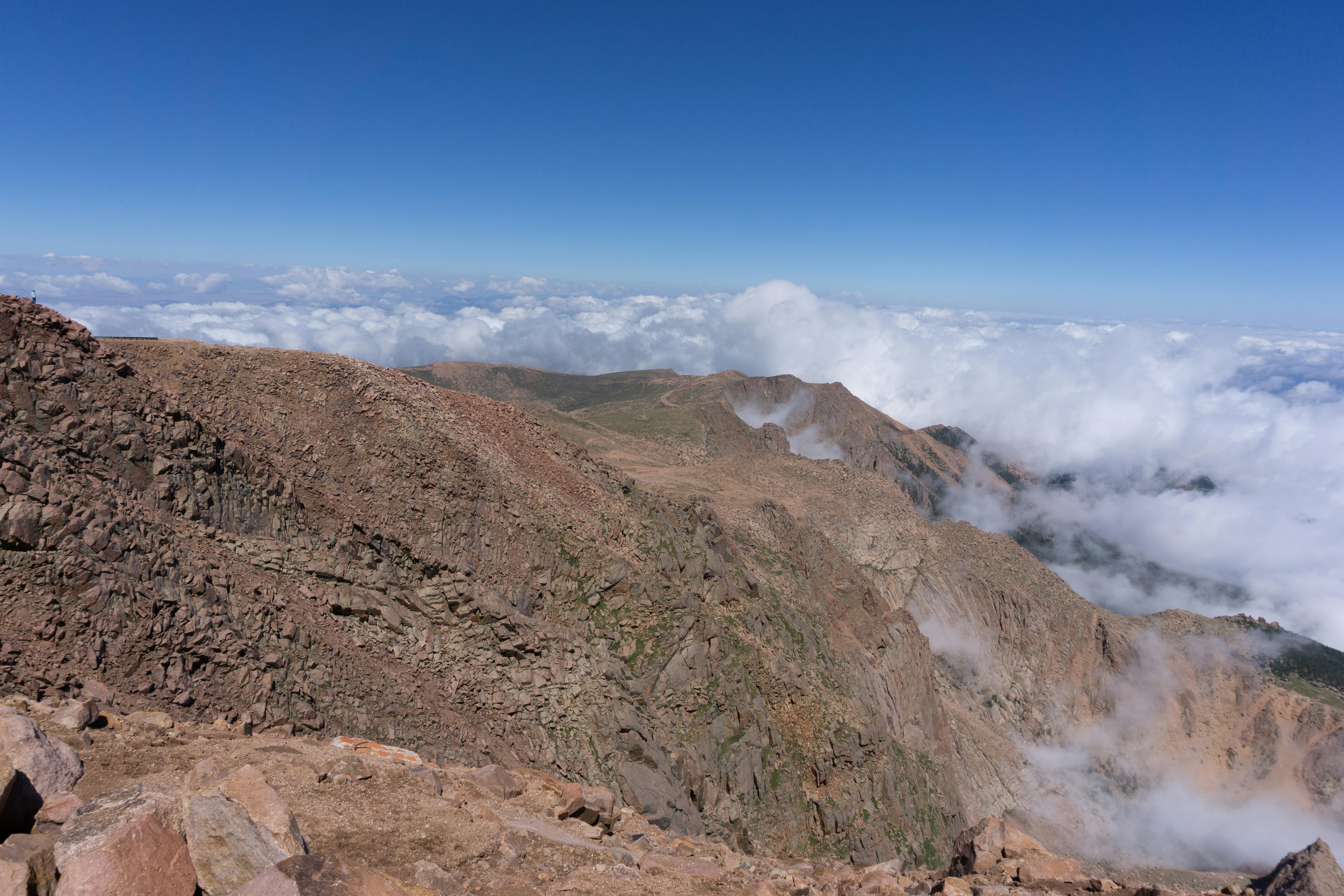 A stunning aerial view of Pikes Peak in Colorado, showcasing rocky terrain and clouds.