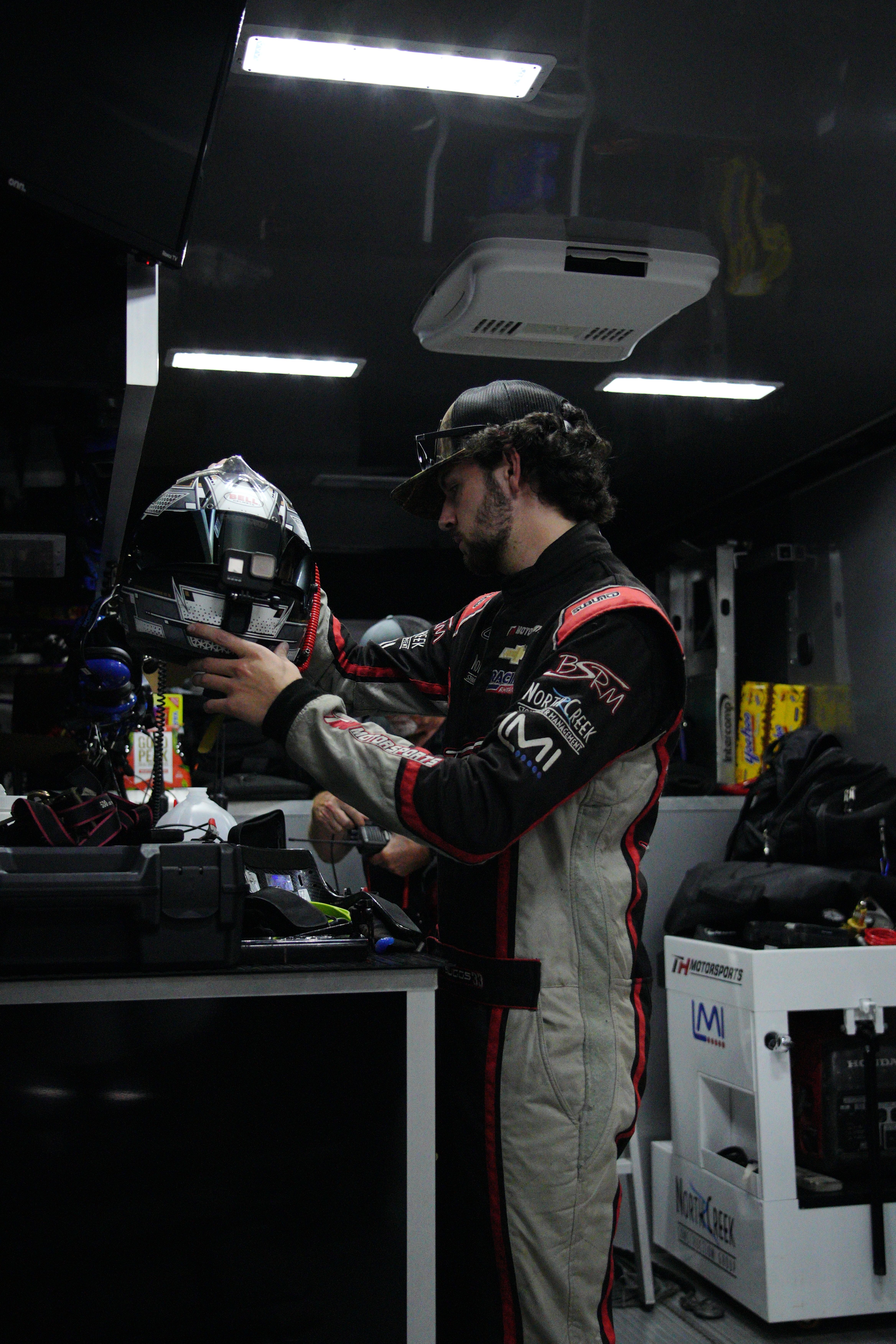 A Racing Driver Standing in a Garage and Holding His Helmet · Free ...