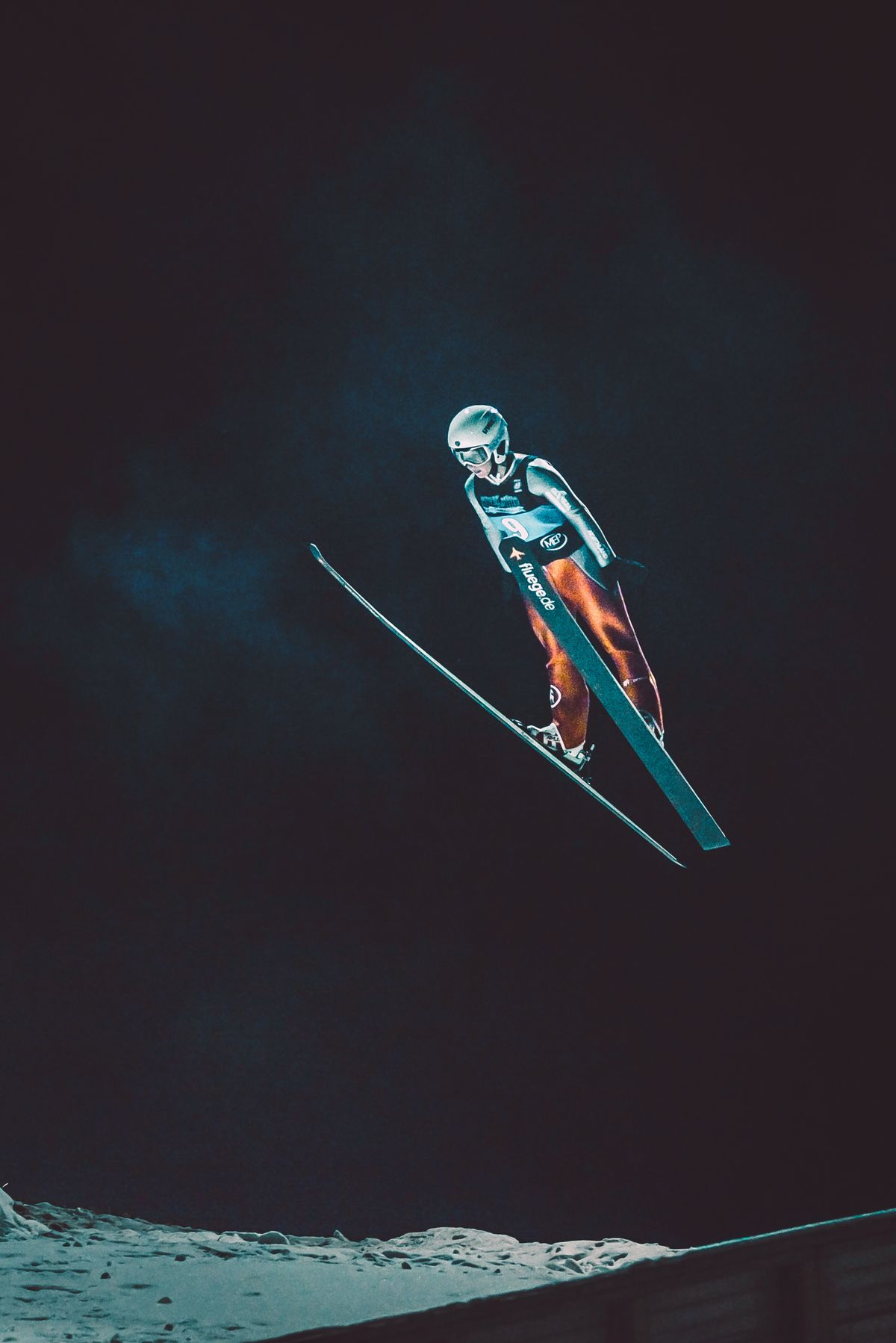 Aerial freestyle skier under stadium lights