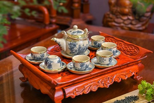 Free A beautifully ornate Vietnamese tea set with cups and saucers on an intricate wooden tray. Stock Photo